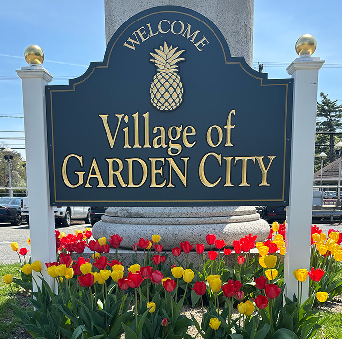 A carved wooden sign welcomes people to the city of Garden City, Long Island, NY