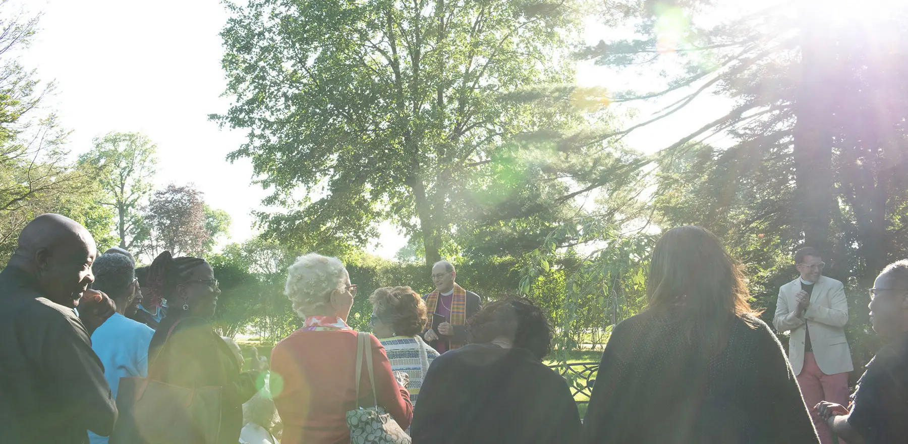 A group of people gather in the meditation garden in the afternoon sunshine